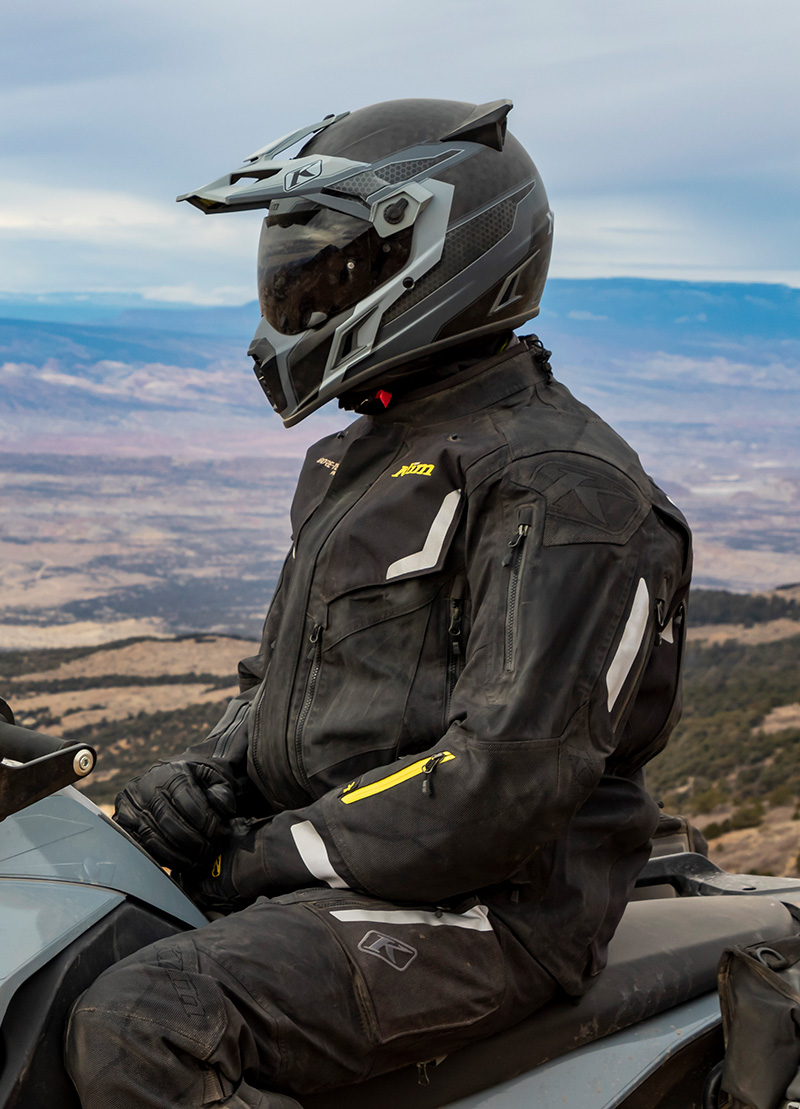 Guy wearing Klim Krios Pro helmet and Badlands suit off-road